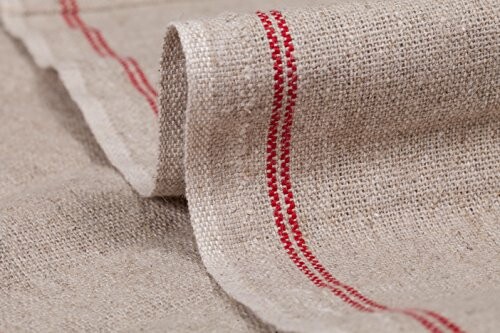 Close-up of beige fabric with red stripe.