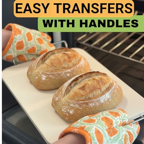 Two loaves of bread on a tray with handles, being placed into an oven with oven mitts.