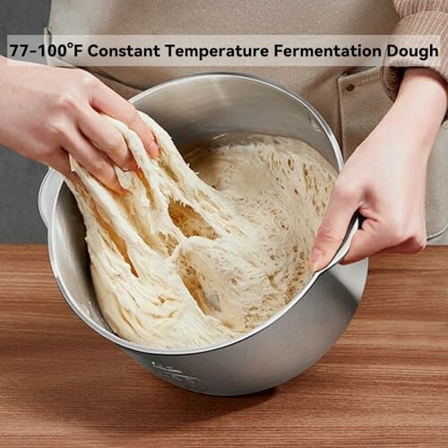 Hands stretching dough in a mixing bowl labeled 77-100°F constant temperature fermentation.