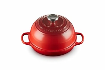 Red cast iron Dutch oven with handles and a lid.
